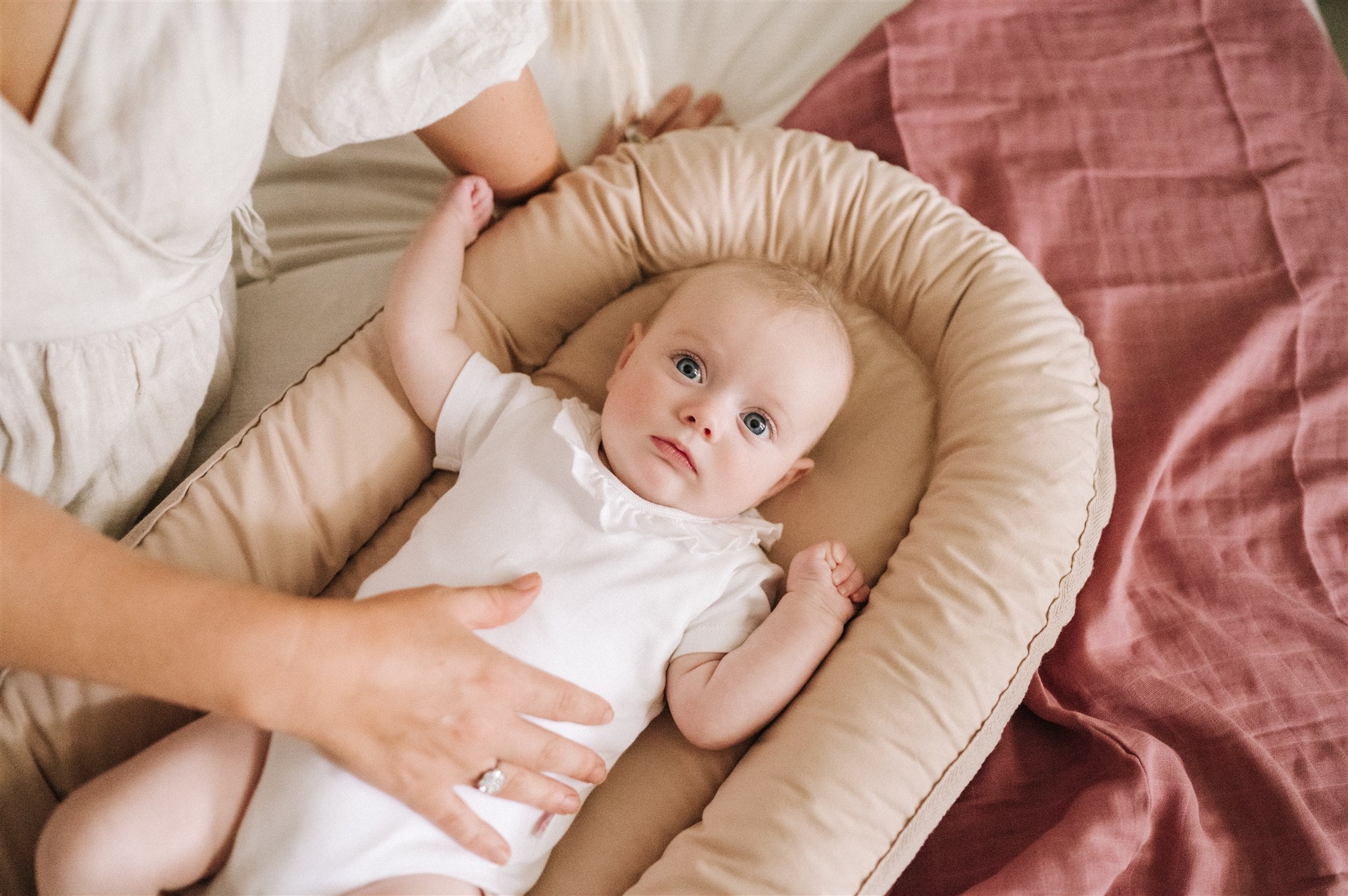 Newborn resting in latte Bubnest baby nest made from GOTS-certified cotton